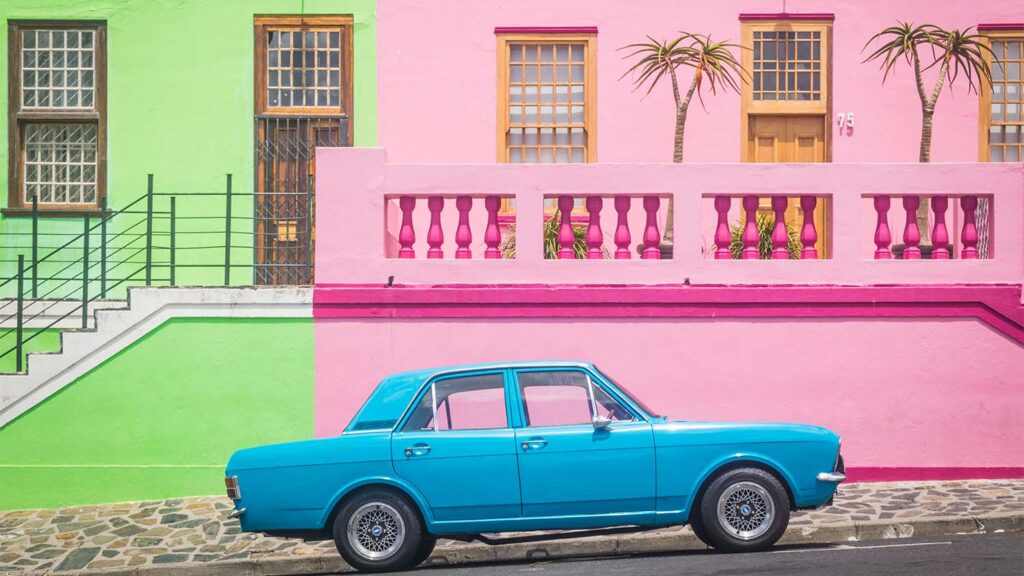 A blue car in front of a pink and lime green building - the dos and don'ts of color theory in web design