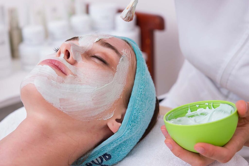 client receives a facial treatment inside a spa - spa marketing is essential to attract your best clients