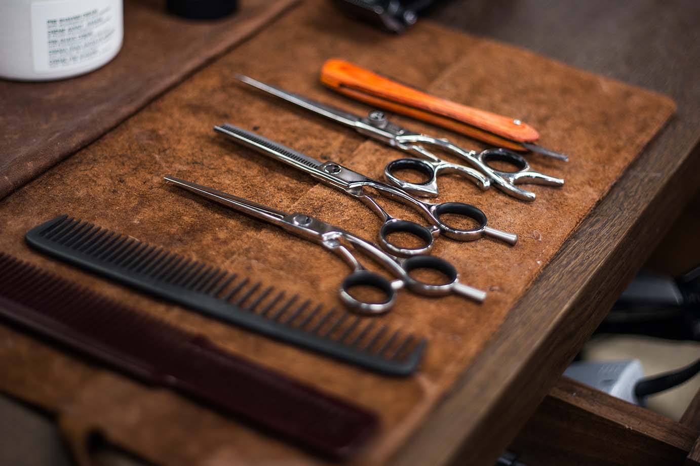 Scissors and other tools on a towel on a work station in a salon; promoting your salon keeps customers & referrals