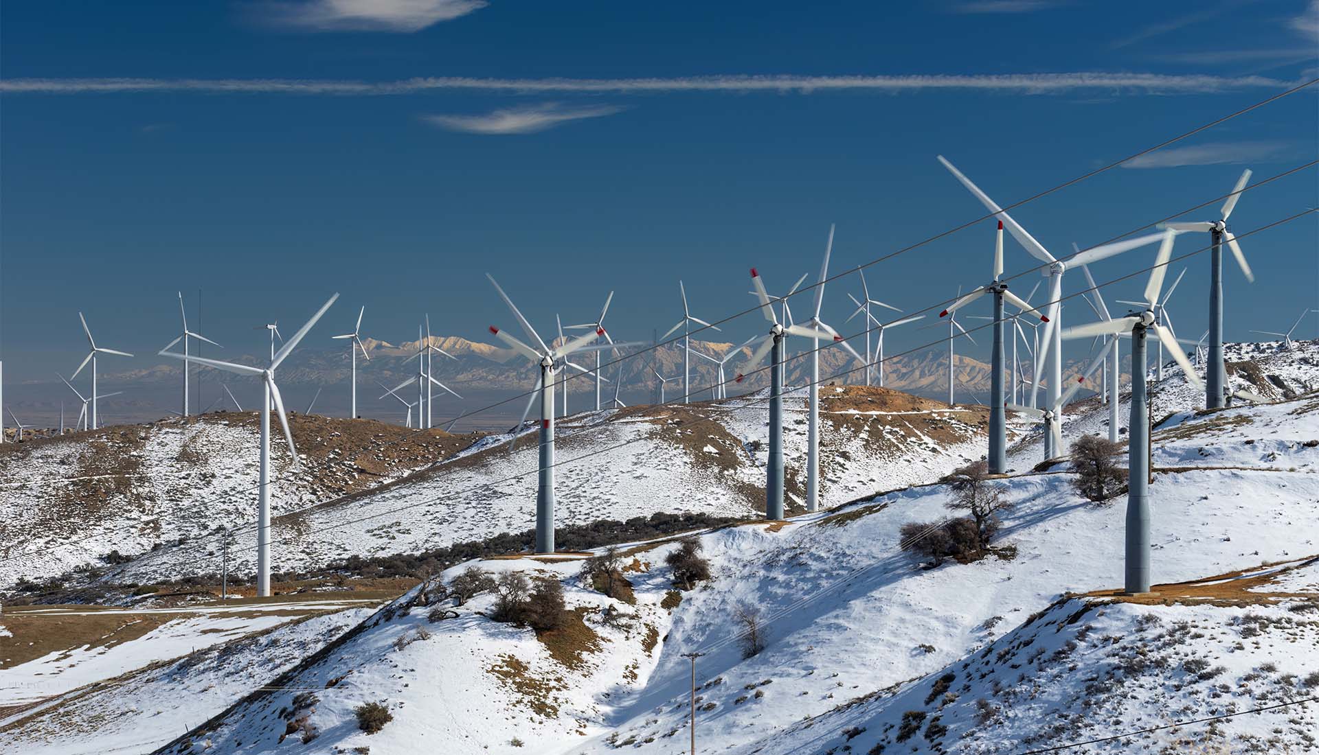 Tehachapi windmills solar farm showing snow-covered hills
